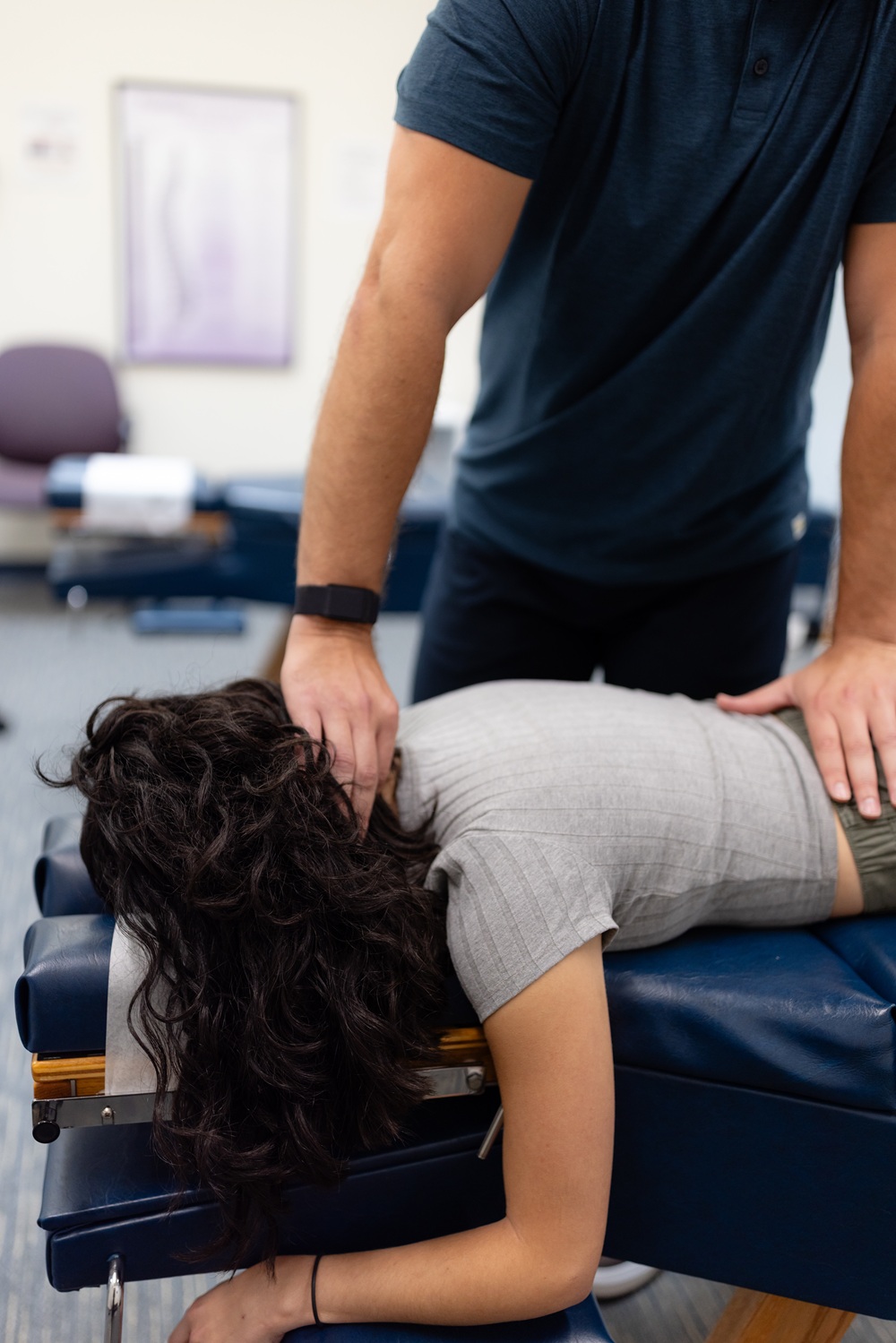 Spinal adjustment for back pain relief in San Diego Chiropractor performing a neck and lower back adjustment on a patient lying on a treatment table