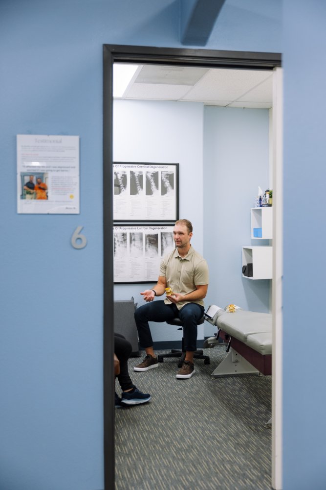 Patient consultation in a Mission Valley, San Diego chiropractic treatment room Chiropractor explaining spine anatomy using a model during a patient consultation